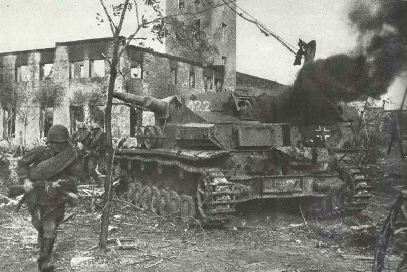 Russian soldiers storm at a burning, outdated PzKpfw IV