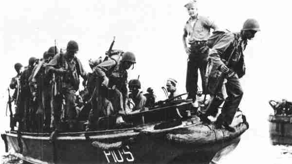 U.S. soldiers are leaving landing boats on the coast of New Guinea.