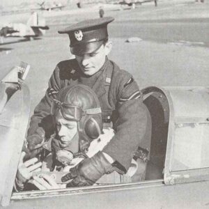 Polish pilot is helped into his plane by a Polish Air Force corporal