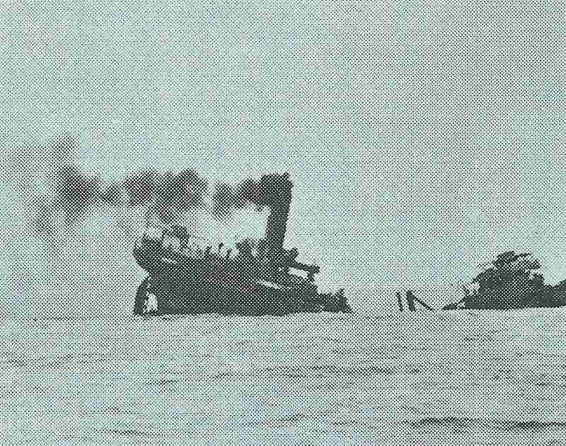 A torpedoed cargo ship sinks.