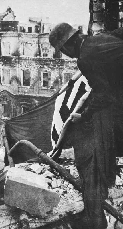 German soldier hoists a Swastika flag at Stalingrad