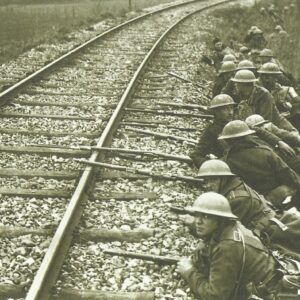British troops take up position behind a railroad embankment