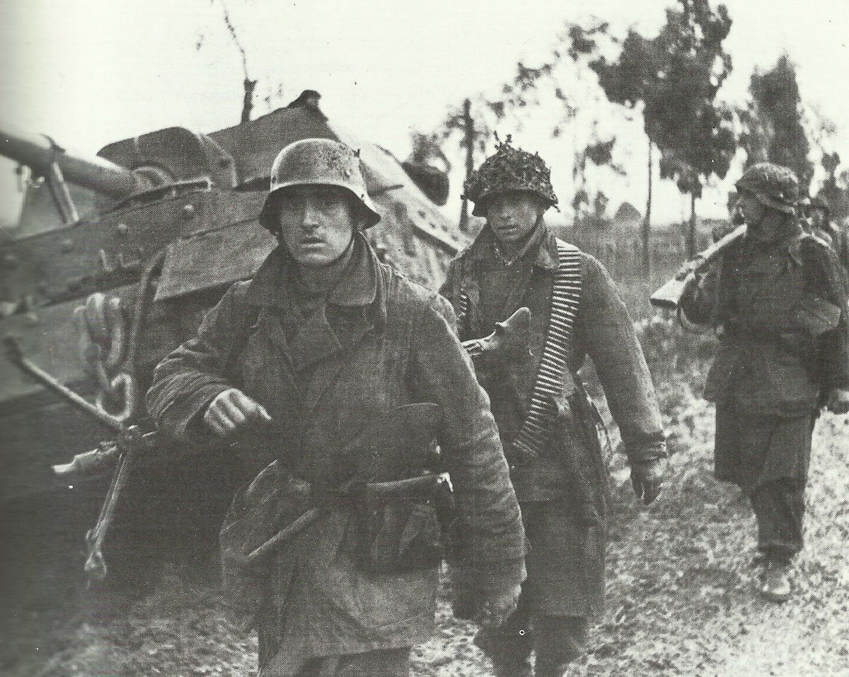 German infantry from a Luftwaffe unit pass a disabled tank destroyer Elefant