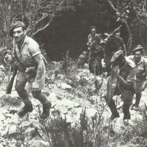 British soldiers trudge up a rocky hillside