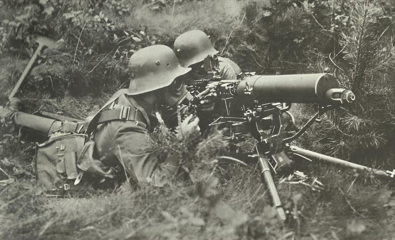 German machine gunners wearing gas masks.